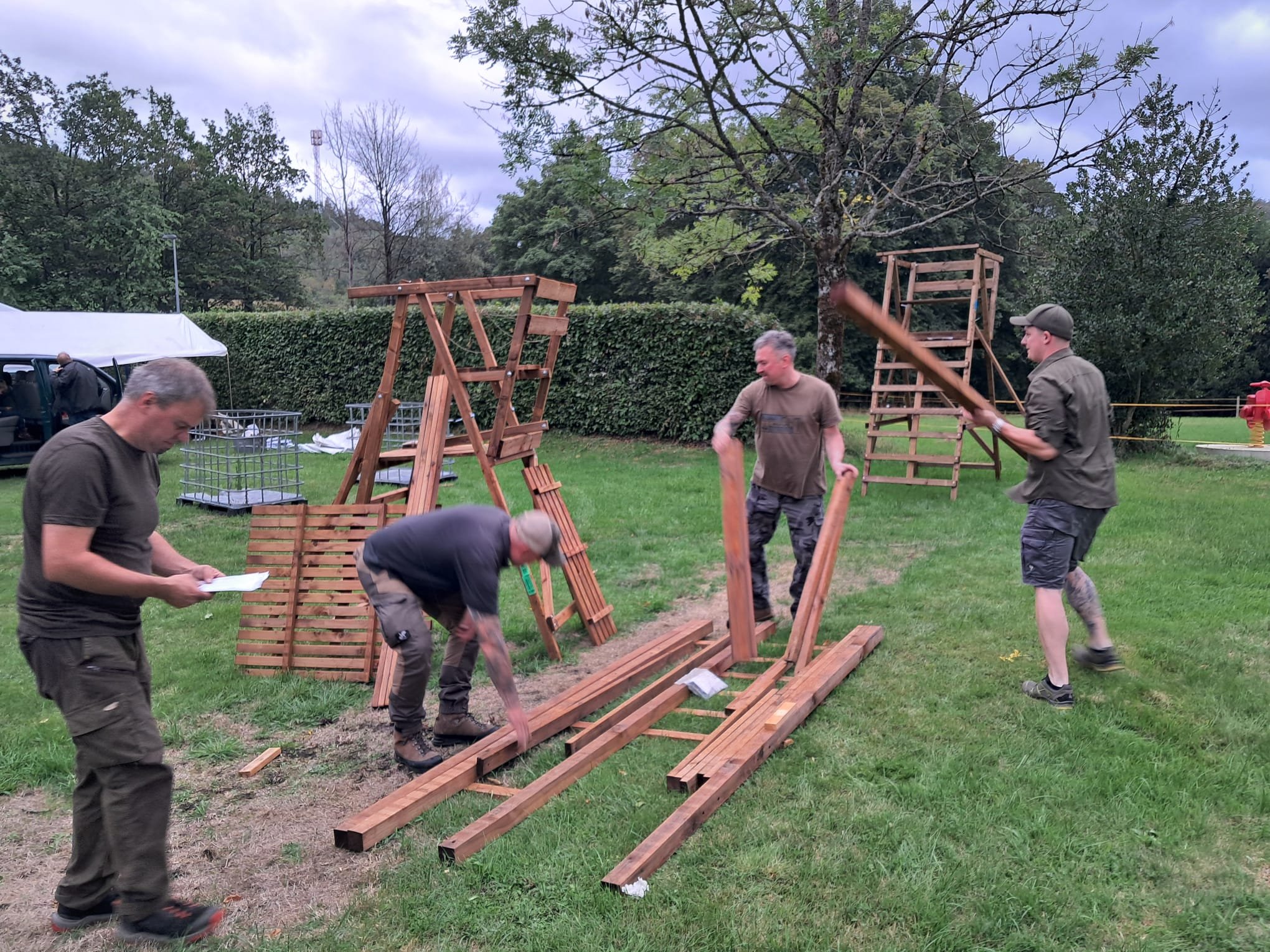 Helfer bauen einen Hochsitz zusammen