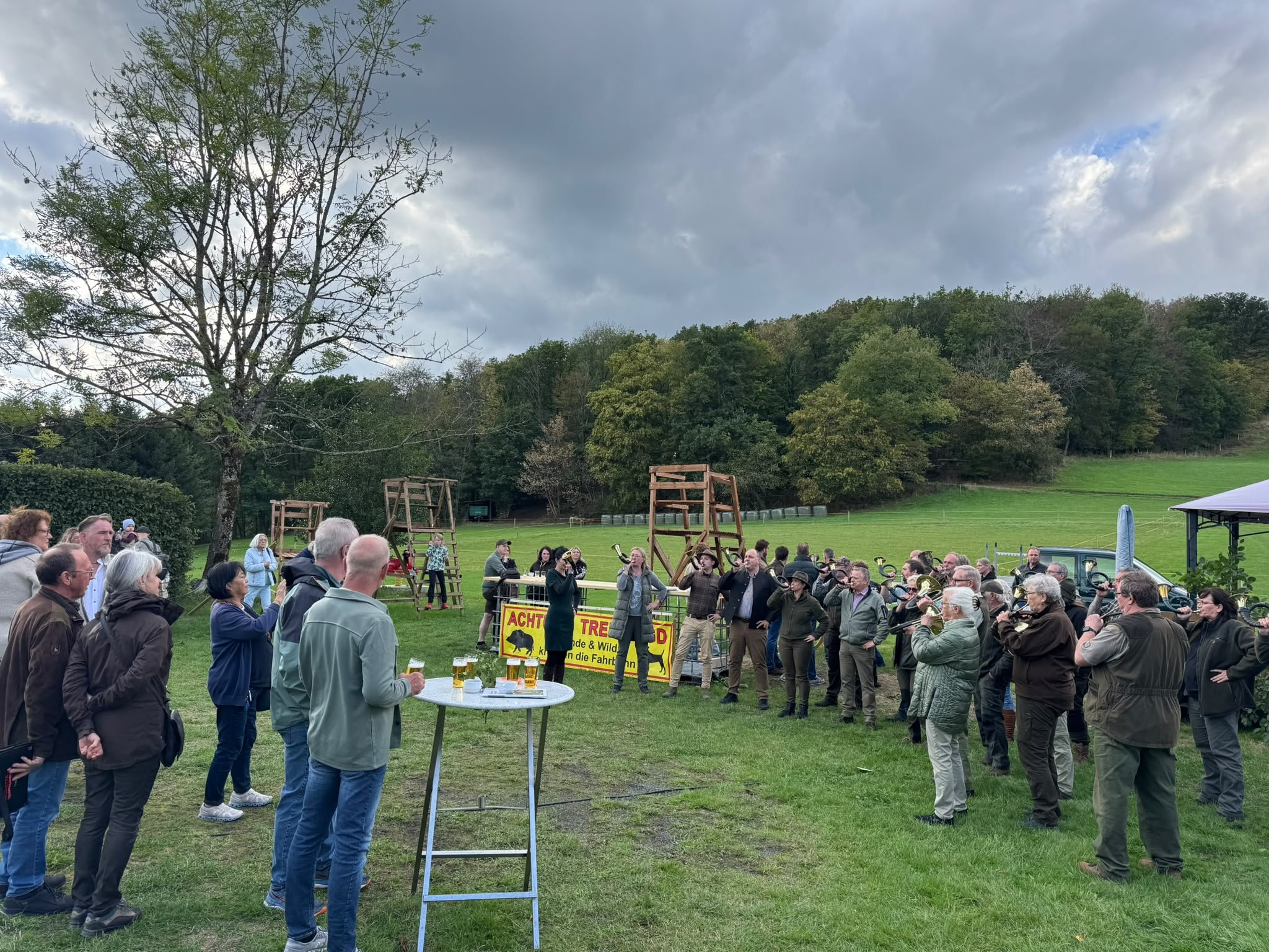 Die Gäste stehen im Kreis auf der Wiese