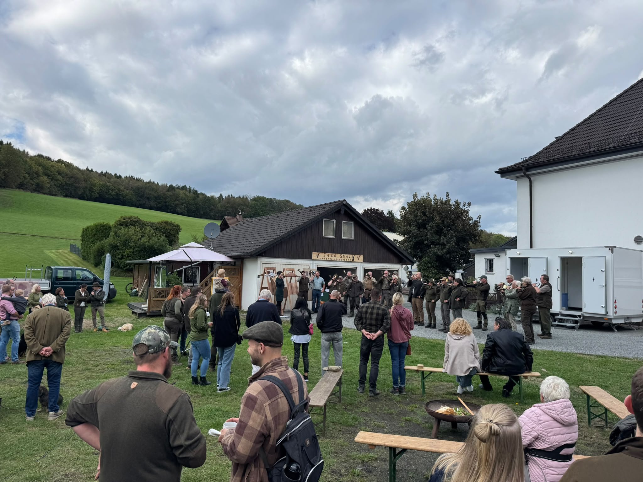 Gäste auf der Wiese vor den Gebäuden des Hofs